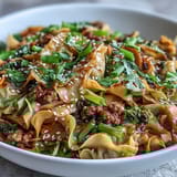 Fragrant garlic, ginger, and sesame seeds garnish these comforting Potsticker Noodle Bowls served with fresh lime wedges.  