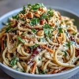 Asian Peanut Noodle Bowl served with lime wedges and fresh cilantro, perfect for a quick vegetarian lunch.