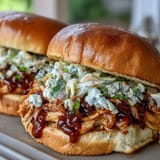 Juicy shredded chicken in smoky barbecue sauce, served on buns with crisp coleslaw topping.  