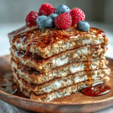 Fluffy High Fiber Protein Pancakes dusted with cinnamon, topped berries.
