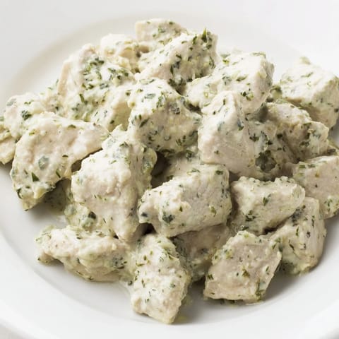 Freshly prepared Green Goddess Chicken Salad featuring juicy chicken chunks, avocado slices, and cherry tomatoes over mixed greens.