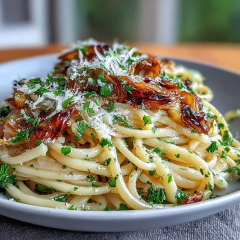 Plate of cabbage pasta with garlic and Parmesan, garnished with fresh parsley and lemon zest.