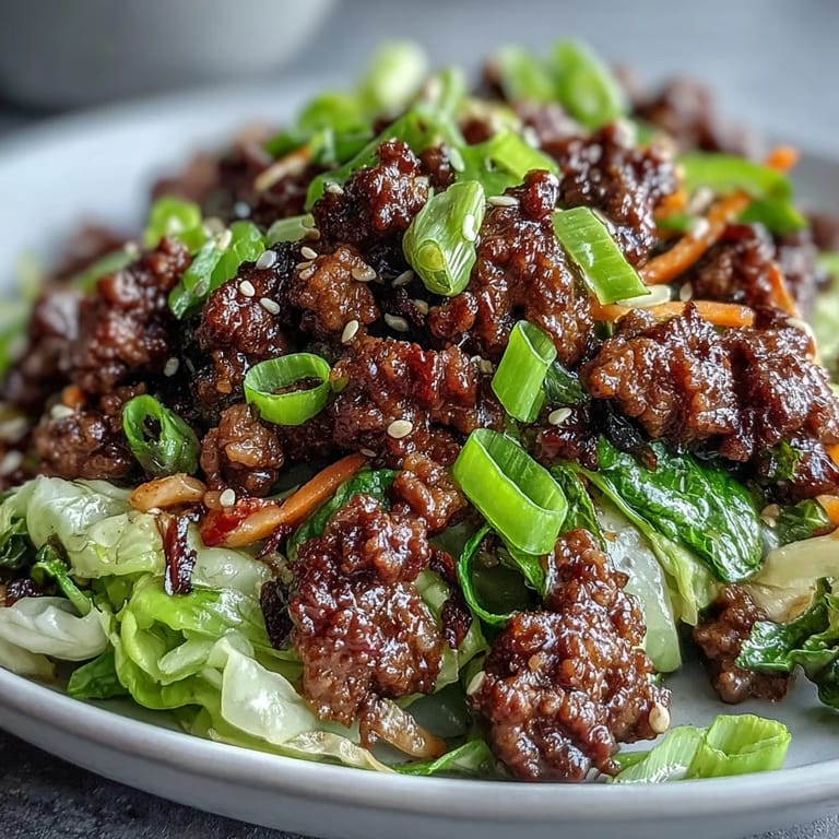Garnished platter of Chinese Ground Beef and Cabbage Stir-Fry topped with sliced green onions and sesame seeds.