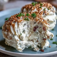 Everything Bagel Deviled Eggs with Cream Cheese topped with crunchy seasoning and fresh chives, served on a white platter.  